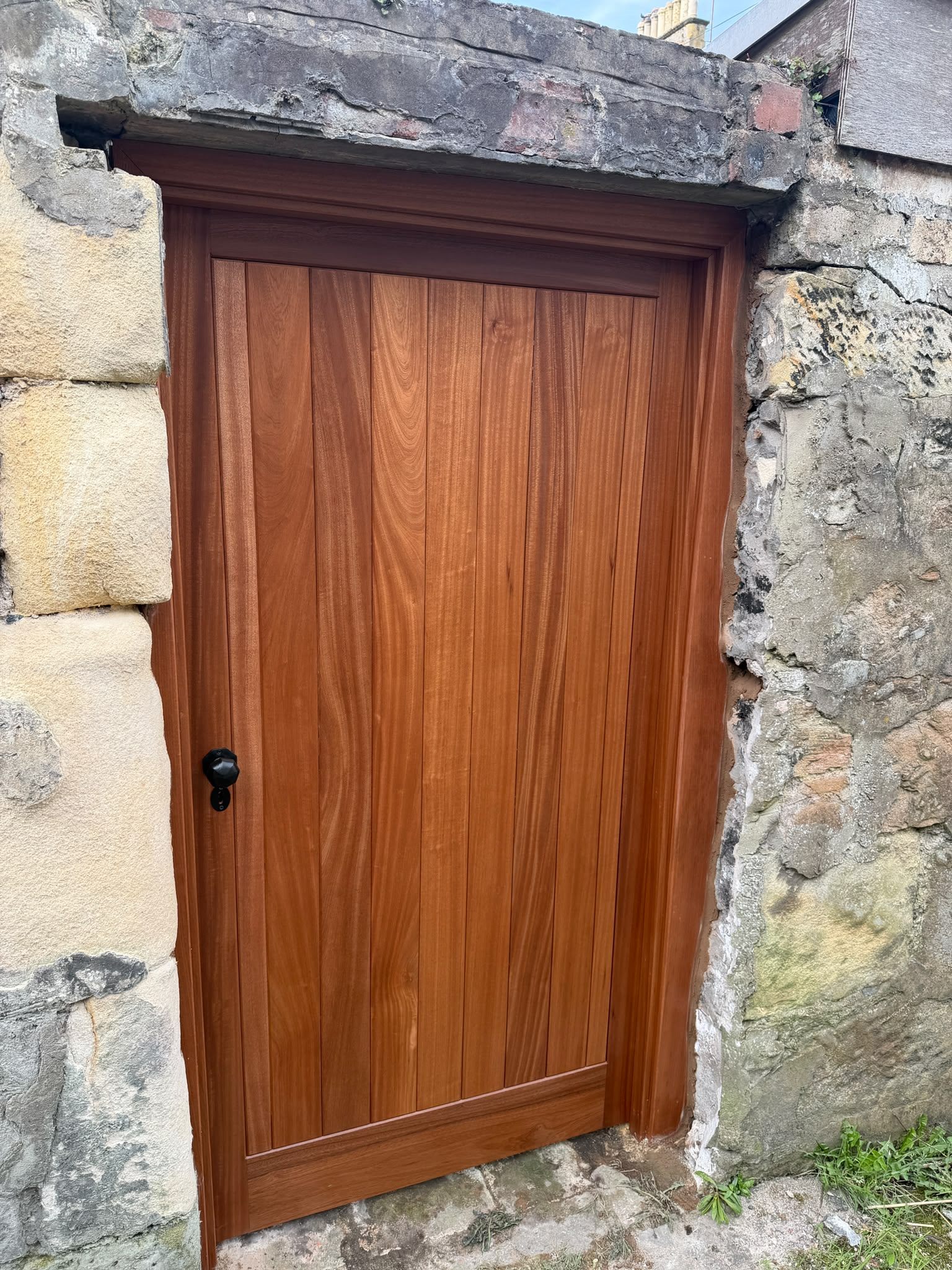 Bespoke hardwood garden door fitted into a stone building